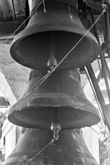 Black and white shot of old bells in a bell tower.