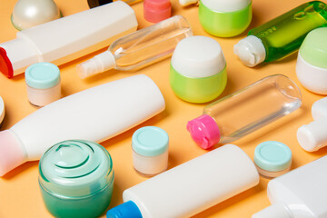 Top view of different cosmetic bottles and container for cosmetics on colored background. Flat lay composition with copy space