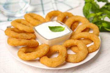 Delicious onion rings with sauce on white wooden table, closeup