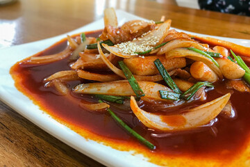 Delicious Korean spicy tteokbokki. The image of spicy tteokbokki on wood background