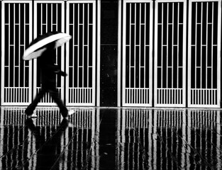 Abstract of a man with the umbrella walking in the rain. Monochrome