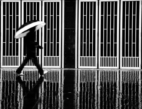 Fototapeta Abstract of a man with the umbrella walking in the rain. Monochrome
