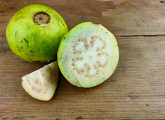 Guava amrud cut slices white pulp on wooden background with Space for text