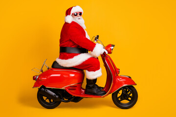 Profile side view of his he nice funny hipster white-haired Santa riding motor bike way road destination travel trip rout Eve Noel isolated bright vivid shine vibrant yellow color background