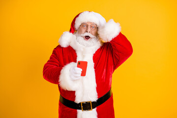 Oh no i send congratulations sms wrong x-mas christmas party. Amazed grey beard santa claus use smartphone touch cap hand wear red style costume isolated bright shine color background