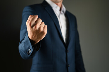 A man in a suit threatens with his fist