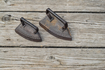 Old antique irons on vintage wooden background