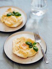 Fluffy Cloud Eggs. Trendy food - oven bake scrambled eggs with whipped egg white and whole yolk on plate Vertical.