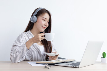 Young Asian woman works on paperwork in her own home online.