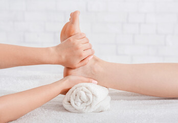 Foot massage in spa salon. Masseur does procedure on table