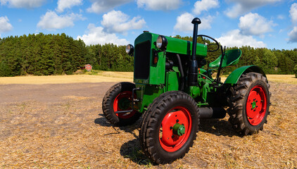Retro tractor on the field near the farm © scharfsinn86