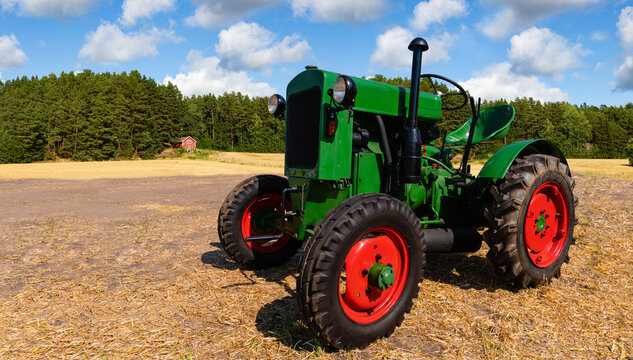 Retro tractor on the field near the farm