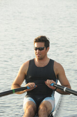 A closeup of a handsome male rower rowing his single shell © charles eberson