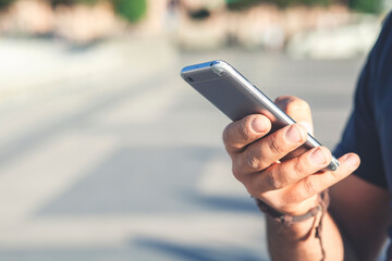 Hand of businessman using while reading his smartphone. Portrait of Hand of business man reading message with smart phone in outdoor.