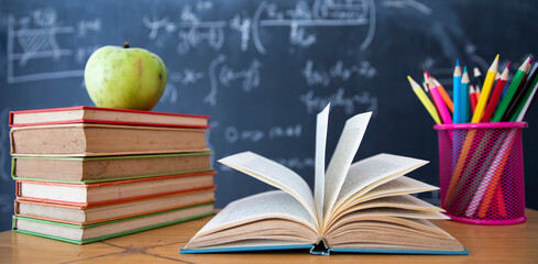 Pencils and book and blackboard. Education concept.