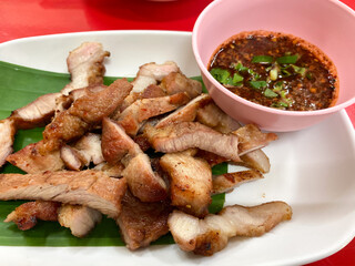 tasty slice grilled pork on banana leaf with thai sauce, thai food
