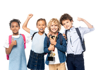 multicultural schoolkids celebrating triumph near curly boy with trophy isolated on white