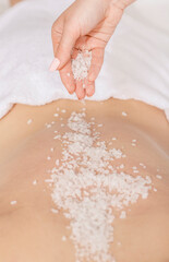 Fototapeta premium Spa scrub massage. Hands sprinkle salt on back of girl