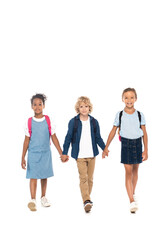 Obraz premium curly schoolboy holding hands with multicultural schoolgirls and walking isolated on white