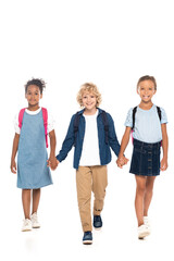 Obraz premium blonde and curly schoolboy holding hands with multicultural schoolgirls while walking isolated on white
