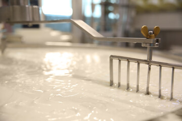 Curd and whey in tank at cheese factory, closeup