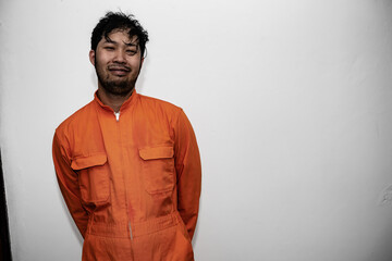 Obraz premium Prisoner in orange robe concept,Portrait of asian handsome man in Prison uniforms,Bandit has a lot of muscle,