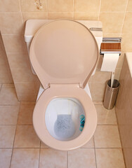 Very old toilet in a brown bathroom