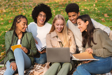 Friends making school homework while spending time in forest