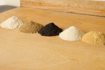 Different types of flour on brown background