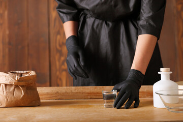 on the kitchen table is a piece of raw yeast dough, male hands are holding a kitchen towel