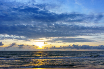 Sunset over the sea. Reflection of sunlight in the sea waves. The sky in the sunset rays.