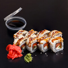 Traditional delicious fresh Unagi Syake sushi roll set on a black background with reflection.