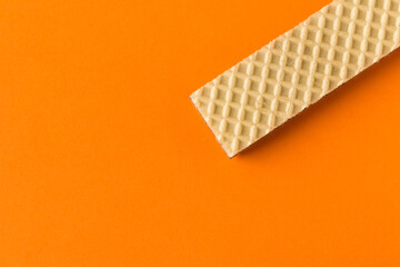 Waffle with chocolate on orange background. Selective focus. Close up.