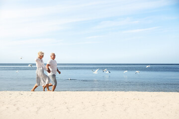 Happy mature couple spending time together on sea beach