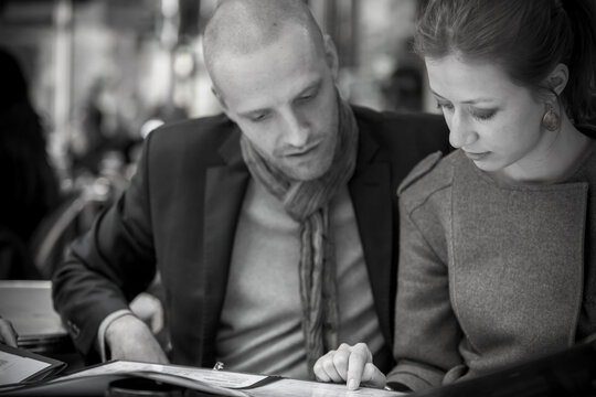 Couple looking over menu in Paris cafe