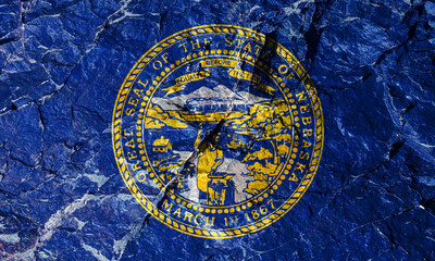 The US National Flag of Nebraska is a blue canvas with the center of the state seal, made of gold and silver for Independence Day on a mountain wall. Rock graffiti of climbers during the ascent.