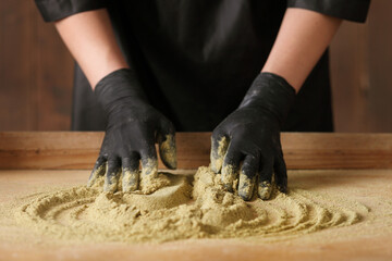 The cook kneads the mustard flour on wooden background