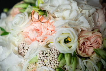 Fototapeta premium Romantic decorations, white light flowers for the holiday, wedding rings for the bride