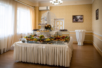 Wedding sweets, decorated tables, decorations and cupcakes, delicious meat and delicacies