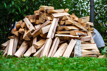 The firewood is stacked on the grass.