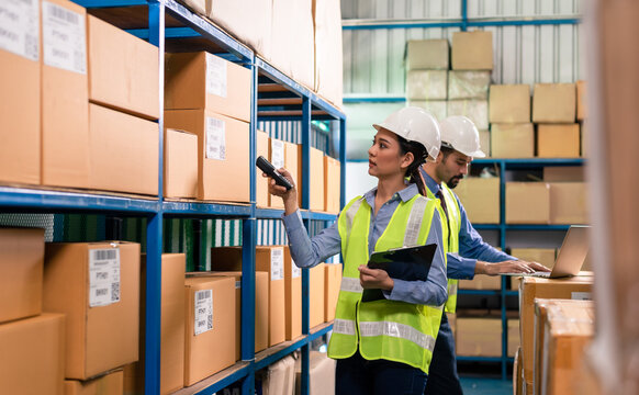 Waman warehouse staff checking stock with bar code scanner