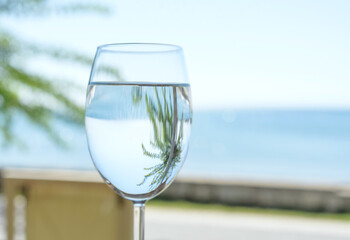 a glass of clear and pure water on the background of the sea