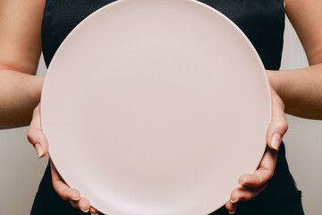 Pink plate in a female's arms. - 375184591