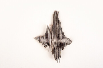 A fragment of dry wood in the form of a rhombus. A piece of wood on a white background. The structure of dry wood resembles the image of sound waves. Fantasy fragment of wood.