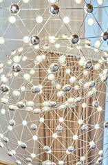 Mesh chandelier made of metal rods with LED lamps