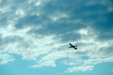 Plane flying high in sky. View to air liner flying in blue sky