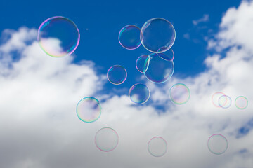 blue sky with white clouds and soap bubbles floating in the air