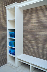 White wooden storage cabinet for towels on wooden slats wall background