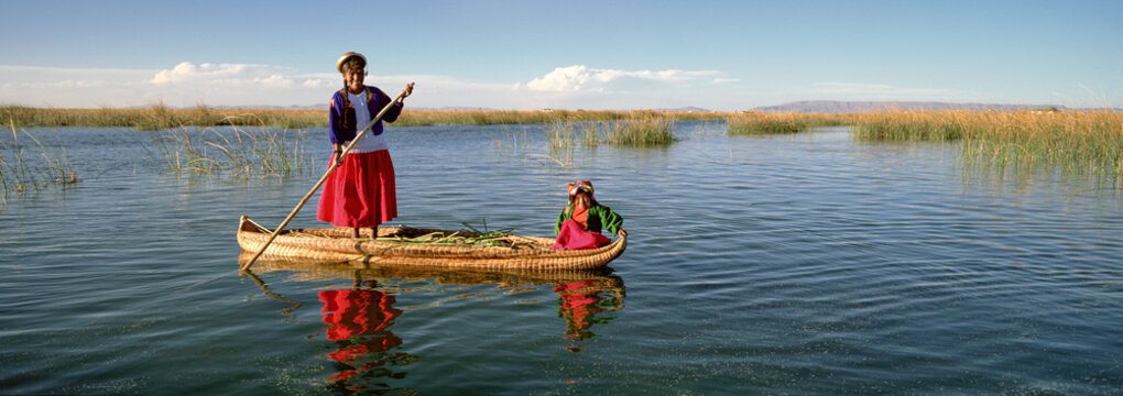 Uros Indian woman and traditional reed boat, Islas Flotantes, Lake Titicaca, Peru, South America