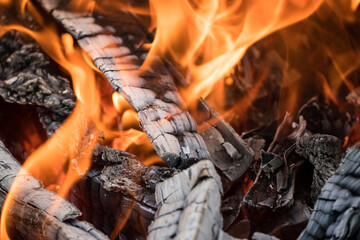 Photo Burning firewood and coals.Flaming burning sparks close-up, fire patterns.View of red hot glowing wood inside stove.Embers and fire in furnace or campfire.Abstract fire flame background